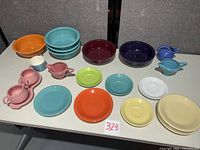 Full lot overview showing assorted colourful Fiesta dinnerware on table