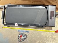 Top view of folded walking pad treadmill with tape measure and accessories bag