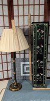 Cabinet closed next to lamp with shade, rulers for scale