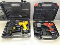 Both drills in open cases with batteries and chargers visible