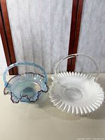 White milk glass basket and iridescent blue-purple basket side by side