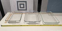 Three rectangular glass baking dishes side-by-side with measuring tape