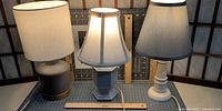 Front view of all three table lamps illuminated showing shades and bases