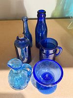 All six blue glass vessels grouped
