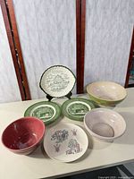 All seven mixed ceramic bowls and plates displayed
