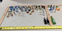 Overview of all miniature figurines and soda bottles with rulers for scale