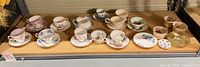 Shelf view of all teacup-and-saucer sets plus additional pieces
