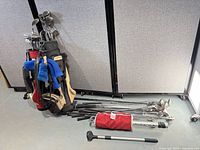 Two golf bags with clubs and loose clubs on floor