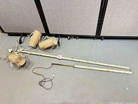 All components of floor lamp laid out, including pole sections, wiring and three drum shades