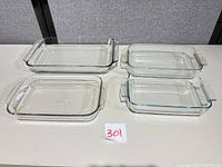 Top view of all four clear glass baking dishes showing shape, handles and relative sizes