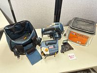 Lot overview showing circular saw, jigsaw, tote, screw bucket, base plate