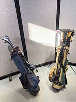 Full view of both golf bags standing with clubs inside
