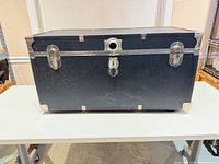 Front view of black Seward steamer trunk showing hardware