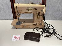 Front view of Singer 403A sewing machine with foot pedal and cords
