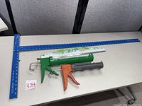 Overall view of T-square, two caulk guns and paint guide