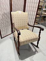Full front view of rocking chair showing upholstery and frame