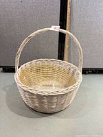 overall view of whitewashed round wicker basket with handle