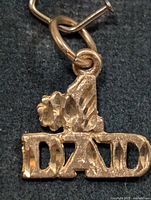 Front view of 10K gold DAD pendant showing lettering and bail