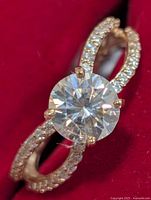 Front view of 10K gold ring with round moissanite and pavé band