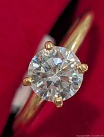 Close-up of round moissanite in claw setting on gold band