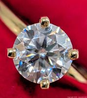 Close-up of round brilliant moissanite in six-prong yellow gold setting