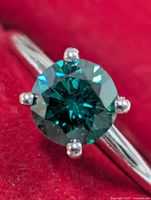 Close-up of teal-green moissanite stone and six-prong setting