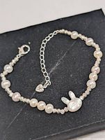 Top view of freshwater pearl bracelet showing pearls, spacers, charm, clasp and extender