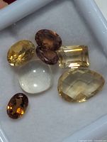Close-up of six loose gemstones showing colour and cut
