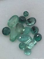 Group of emerald stones showing various cuts and colors