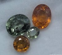 Close-up of four loose sapphires showing colours and cuts