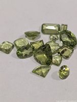 Group of faceted peridot stones assorted shapes