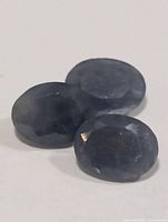 Three oval blue sapphires grouped on white background