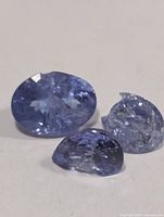 Three tanzanite stones showing color and damage