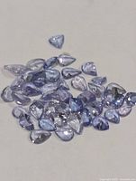 Group of pear-cut violet-blue tanzanite stones on neutral background
