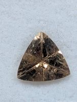 Triangular faceted brown tourmaline loose on white background
