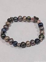 Full view of multicolour Tahitian pearl bracelet showing pearls and butterfly charm