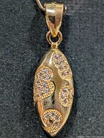 Front view of marquise gold-tone plated silver pendant with CZ clusters
