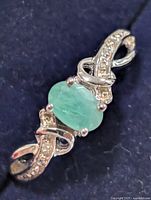 Front view of ring showing emerald and accent stones