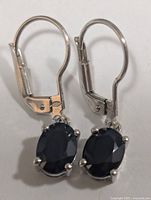 Front view of both sterling silver leverback earrings showing sapphires and prong settings