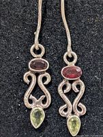 Pair of silver dangle earrings showing stones and design
