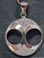 Front view of sterling silver openwork disc pendant with cubic zirconia