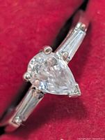 Front view of ring showing pear CZ and baguette sides