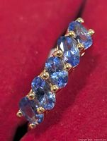 Top view showing seven oval blue tanzanite stones in prong setting