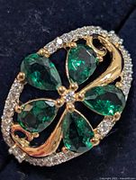 Top view of ring showing chrome diopside petals, CZ border, gold-tone scroll