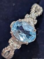 Top view of ring showing oval blue topaz and pavé accents