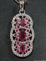 Front view of silver ruby earring showing stone arrangement and border
