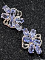 pair of silver earrings with tanzanite clusters front view