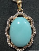 Front view of turquoise pendant with halo of clear stones