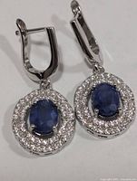 front view of both earrings showing sapphire centres and CZ halos