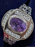Front view of silver ring showing oval amethyst and clear accent stones